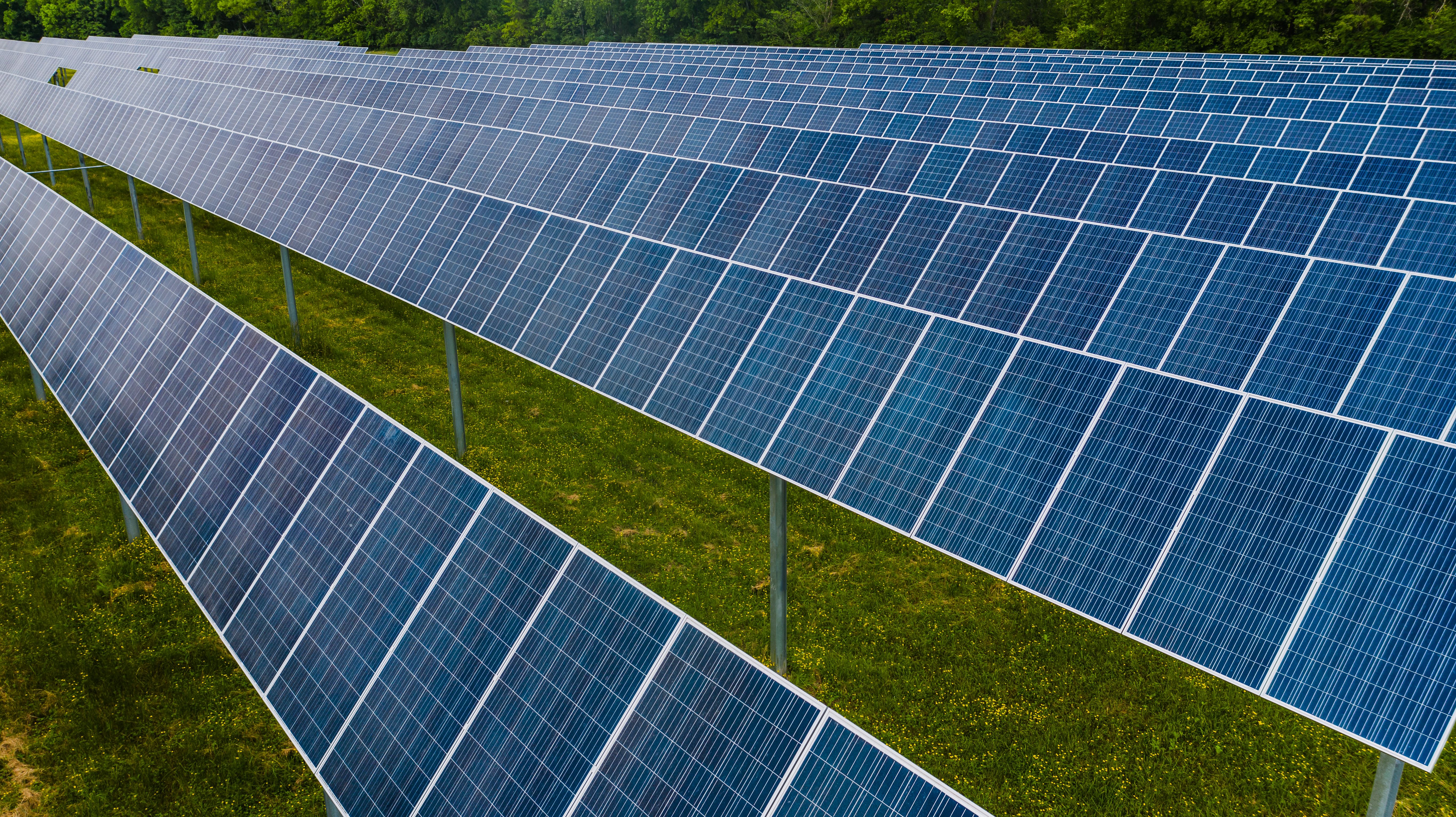 Solar technician monitoring and maintaining solar panel arrays